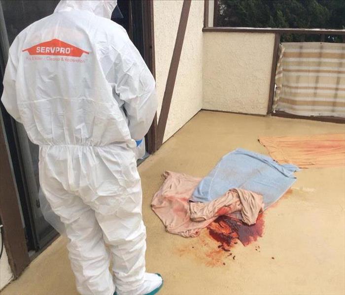 SERVPRO employee in PPE cleaning a crime scene