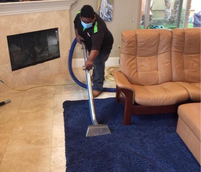 SERVPRO employee extracting water from rug