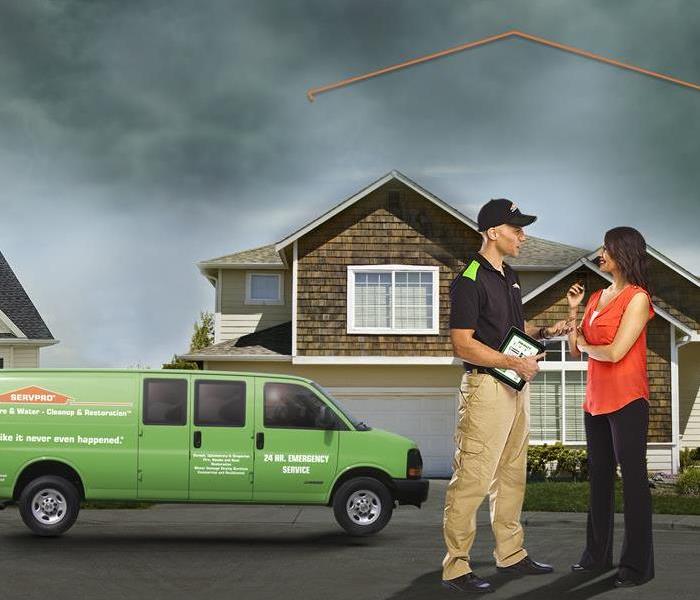 SERVPRO tech and homeowner standing outside a residential property discussing a readiness plan for water damage