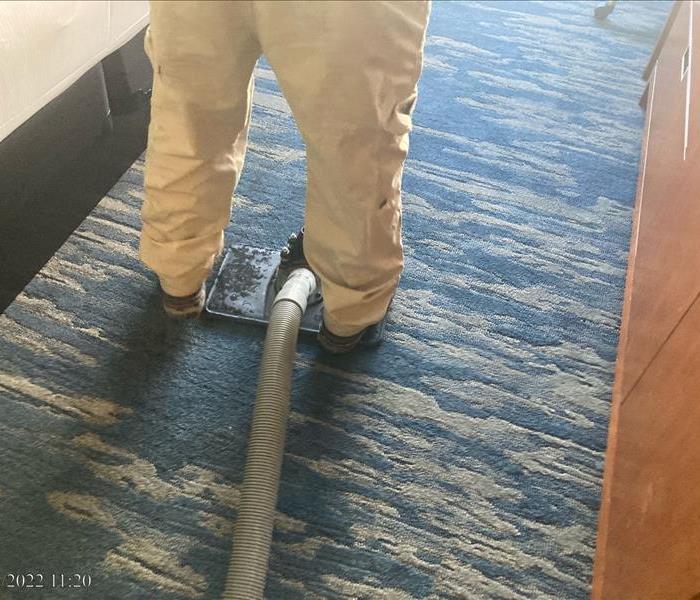 SERVPRO employee using water extractor to remove water from carpet
